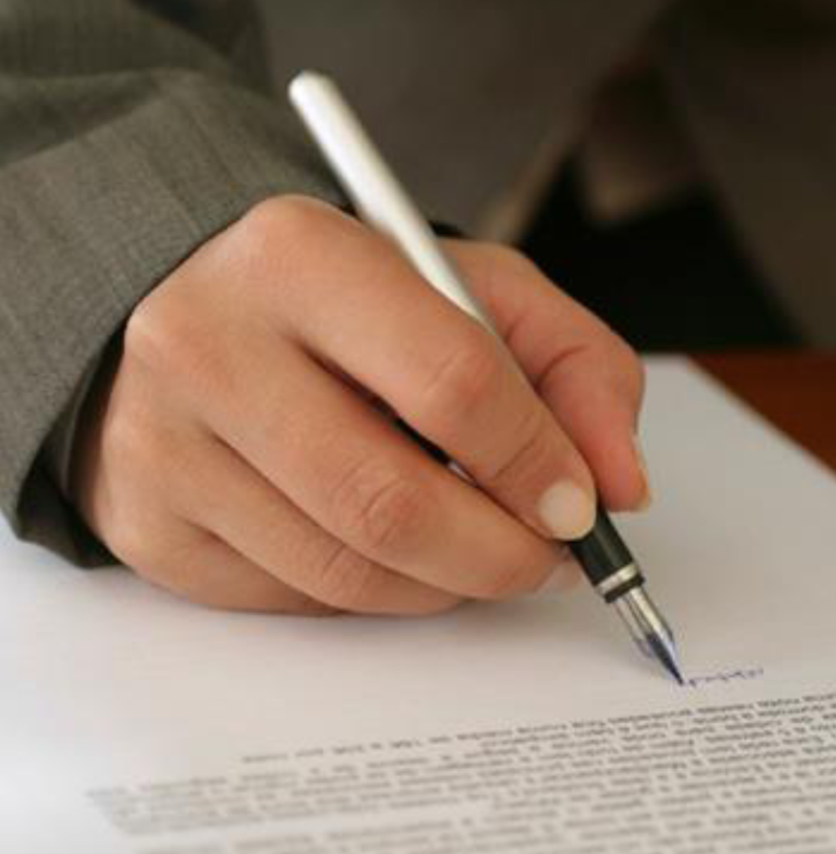 Main tenant un stylo plume écrivant sur du papier