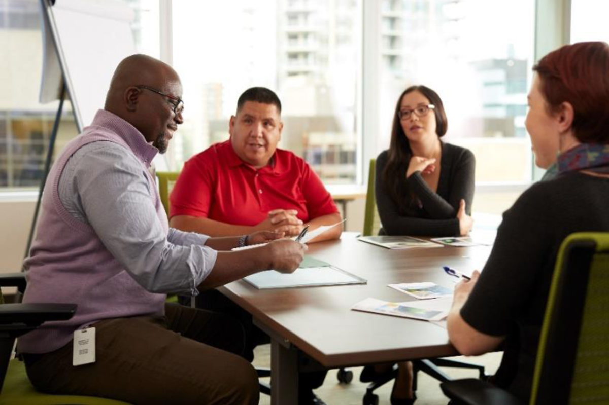 Quatre personnes discutant autour d'une table