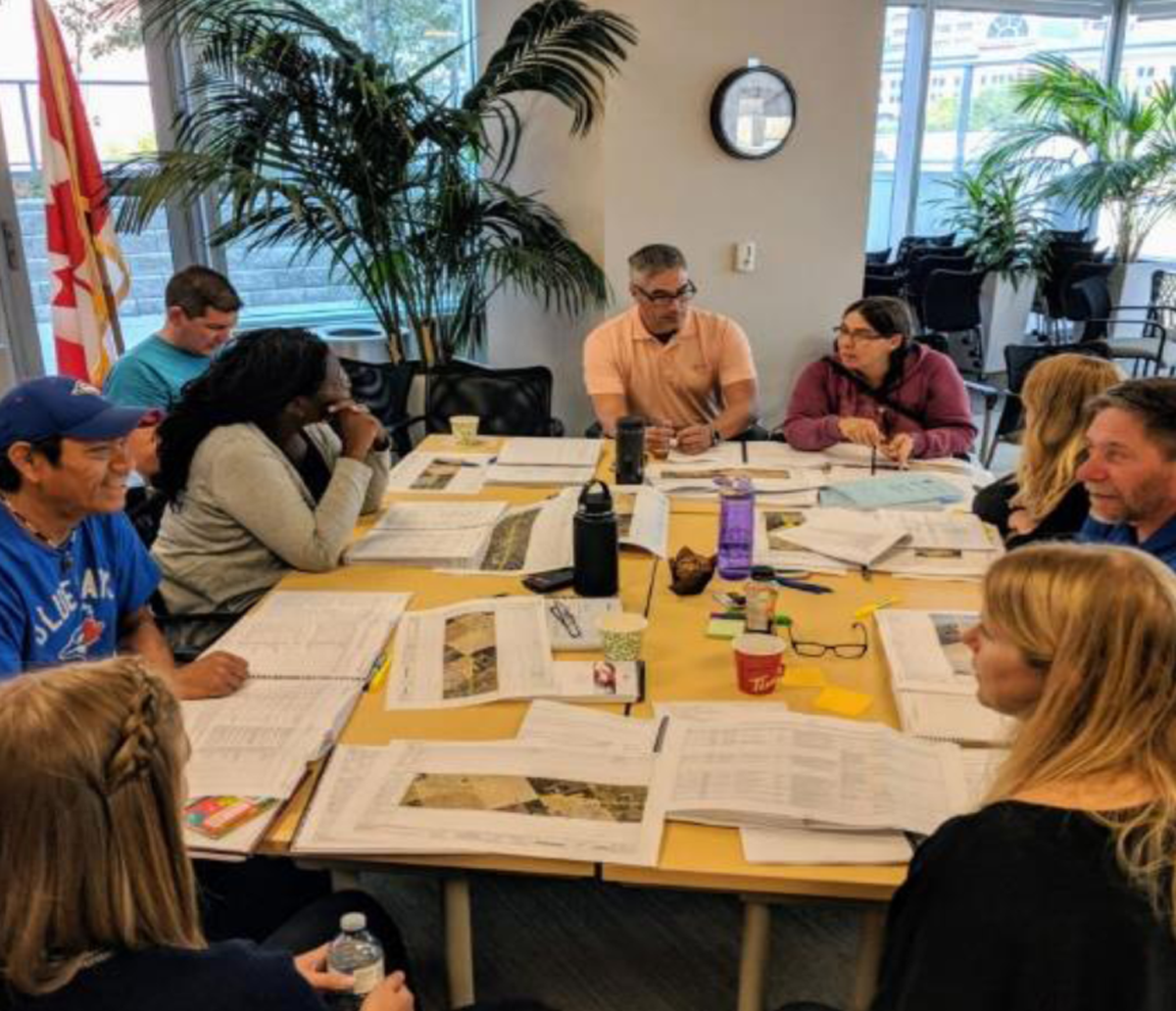 Neuf personnes travaillant autour d’une table