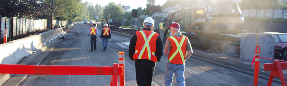Personnel de chantier parcourant une route à pied