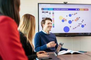 Membres du personnel de la Régie en discussion, données visuelles en arrière-plan.