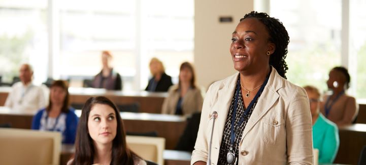Femme prenant la parole à une audience. 