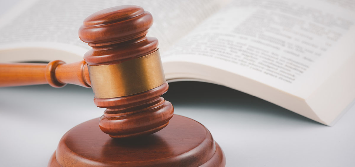 Vieux marteau de juge en bois avec livre de droit sur le fond de bois de table