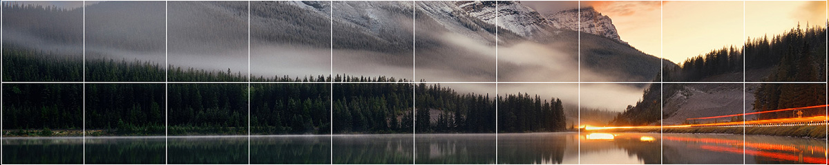 De l’eau calme à côté d’une forêt sous une pente de montagne brumeuse