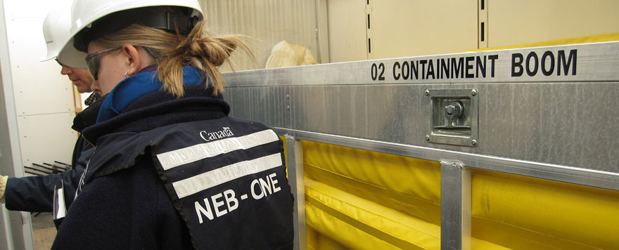 Inspecteurs à l’intérieur d’une unité de confinement des hydrocarbures et d’intervention en cas de déversement