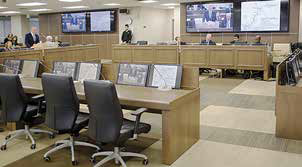 Three woman sitting around a coffee table covered with documents and talking.