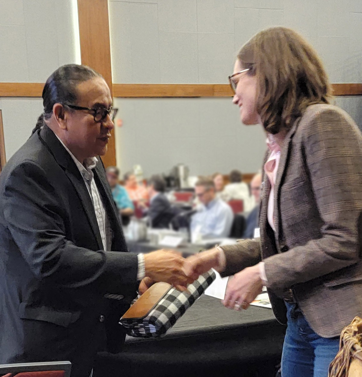 Chief Aaron Young from the Chiniki First Nation talking and shaking hands with former CER CEO Gitane de Silva