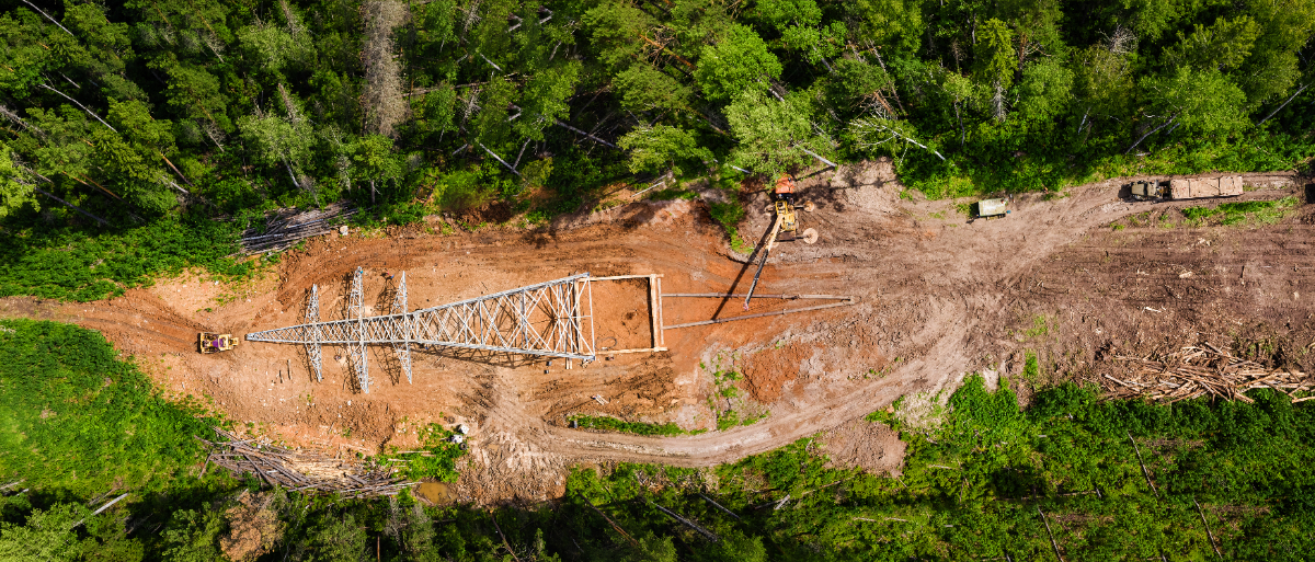 Vue aérienne de la construction d’une ligne de transport d'électricité dans une forêt boréale.