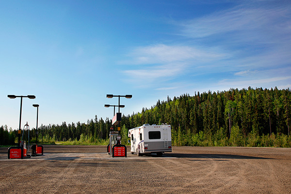 Autocaravane arrêtée à une station-service en campagne pour faire le plein par une belle journée d’été.