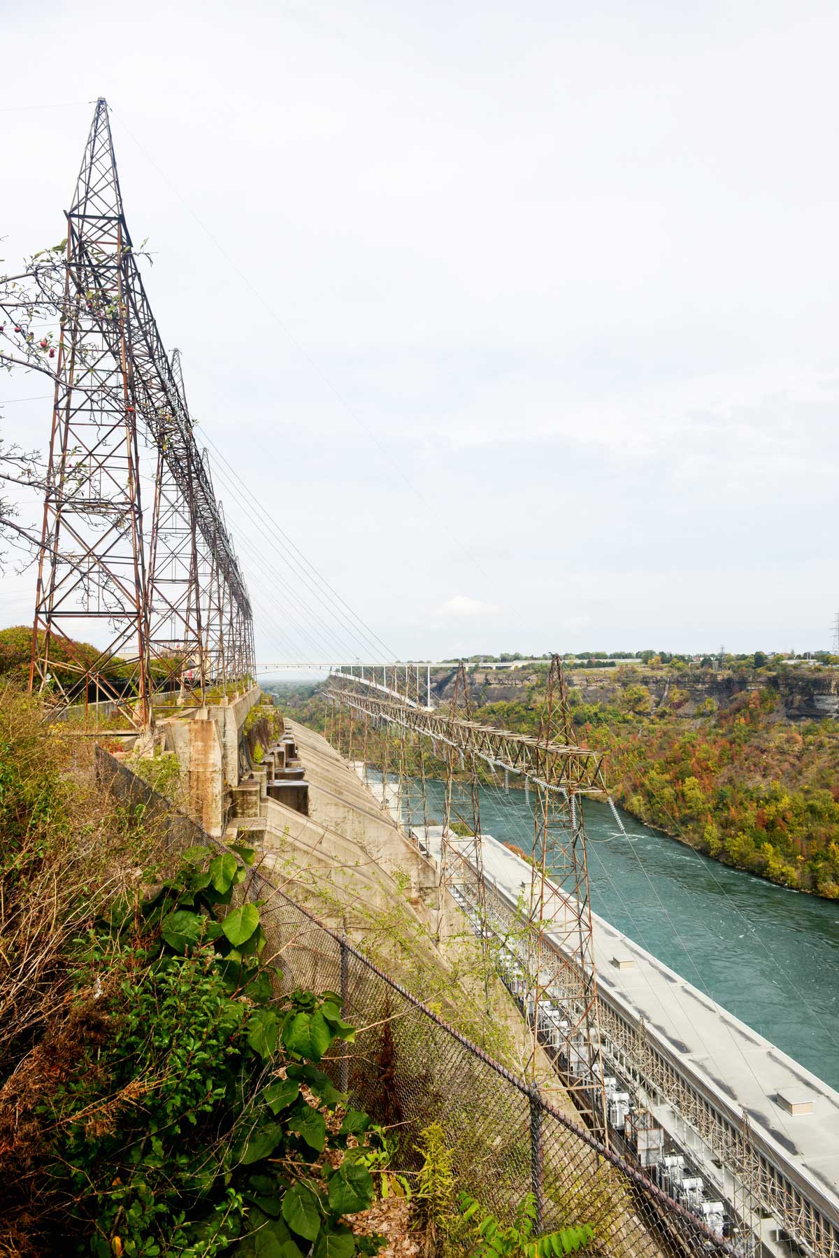 Vue latérale en été de la centrale hydroélectrique Sir Adam Beck avec des lignes de transmission au-dessus de la station et la rivière Niagara en dessous.