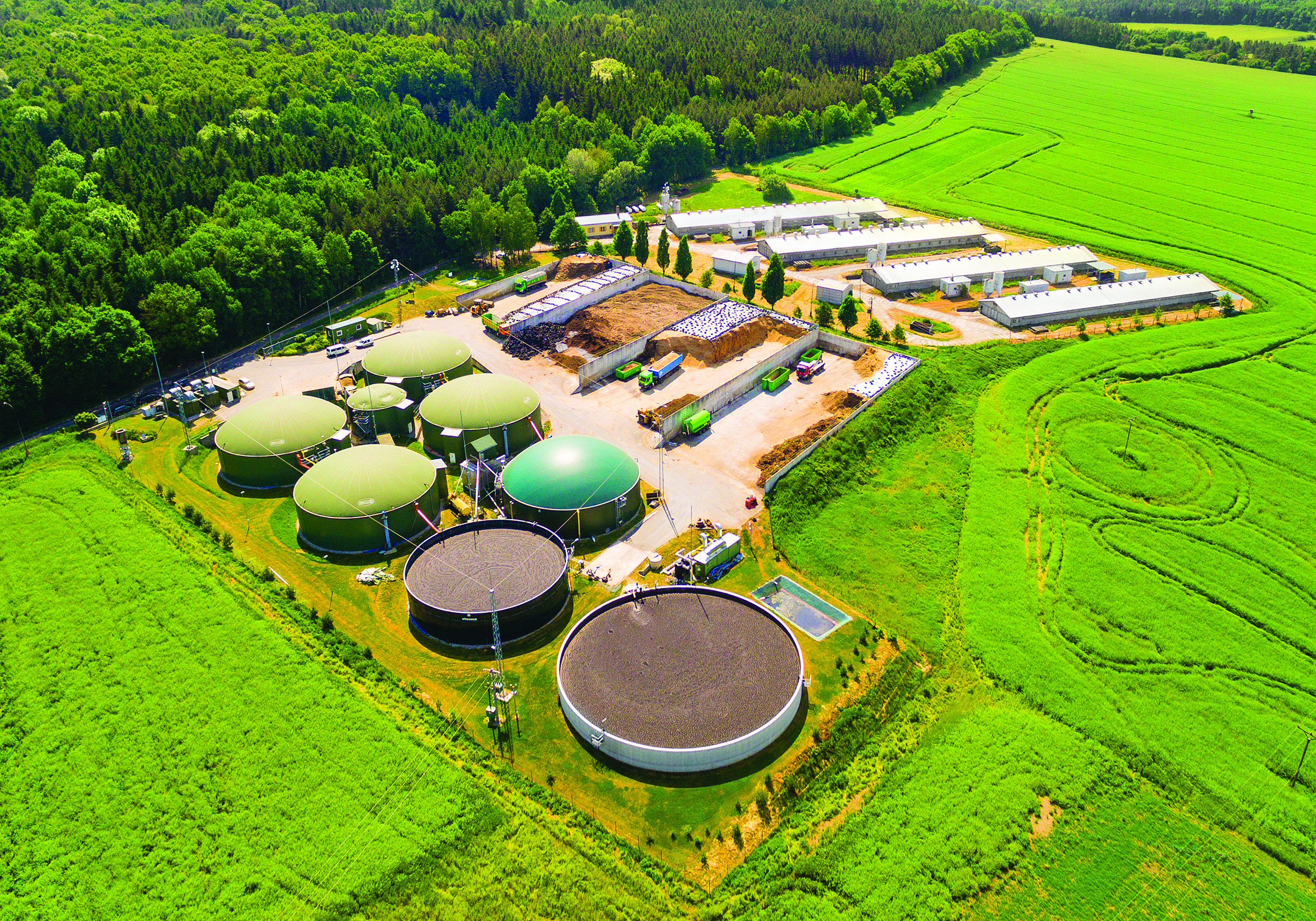 Aerial view over biogas plant and green farmer fields in the Czech Republic.