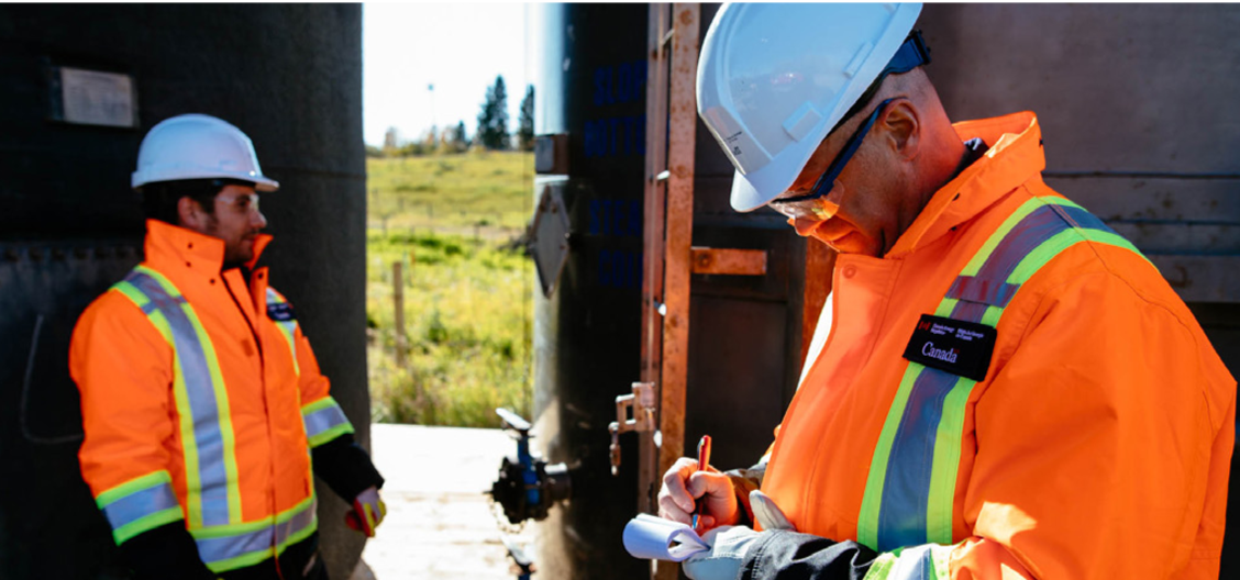 Two CER inspectors in PPE inspect a facility
