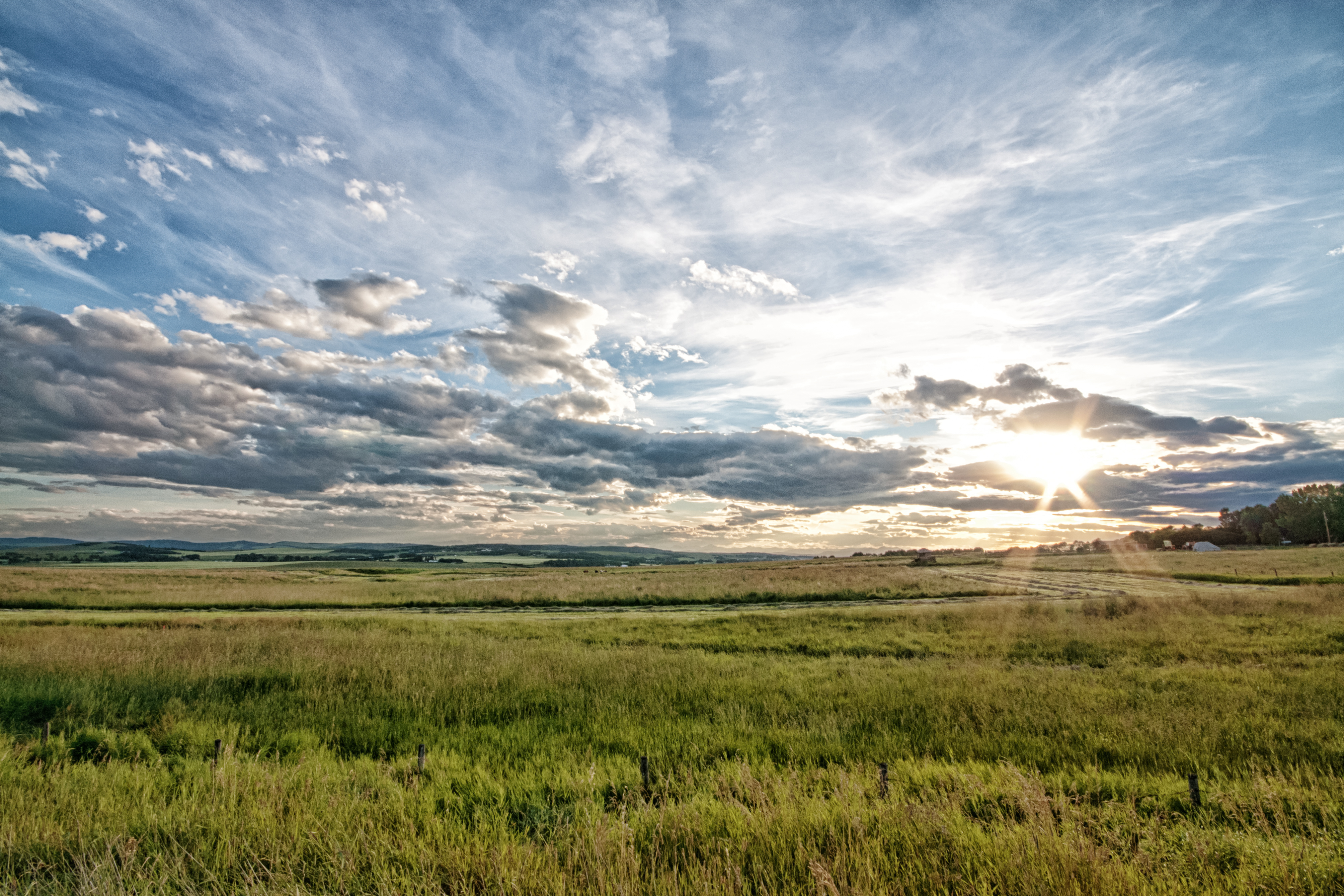 Un coucher de soleil sur les prairies de l’Alberta et des nuages dans le ciel.